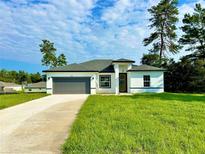 One-story house with gray roof, white walls, and gray garage door at 3137 Sw 127Th Lane Rd, Ocala, FL 34473