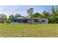 Front view of a single story home with a screened porch at 168 E Sunset St, Groveland, FL 34736