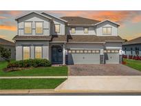 Two-story house with gray siding, three car garage, and landscaped yard at 3198 Sailing Pier Ave, Winter Garden, FL 34787