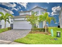 Two-story house with gray-blue door and paver driveway at 1687 Kona Ln, Davenport, FL 33897