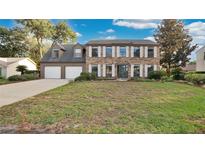 Two-story brick house with a two-car garage and manicured lawn at 7972 Snowberry Cir, Orlando, FL 32819