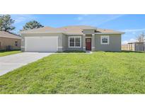 New single-Gathering home with a green lawn and attached garage at 5197 Sw 155Th Loop, Ocala, FL 34473