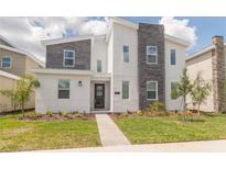 Two-story modern home with gray and white exterior and landscaping at 9102 Sommerset Hills Dr, Davenport, FL 33896