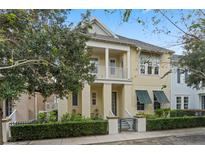 A charming two-story home with a yellow facade, green shutters, and a manicured front yard at 1577 Castile St, Celebration, FL 34747