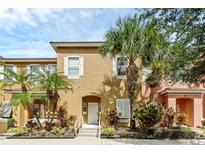 Tan two-story townhouse with white shutters and palm trees at 105 Pompano Beach Dr, Kissimmee, FL 34746