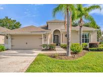 Tan house with palm trees and paved driveway at 500 Arena Dr, Davenport, FL 33837