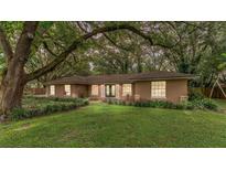 Charming ranch-style home with a well-manicured lawn and mature trees at 115 Polo Ln, Sanford, FL 32771