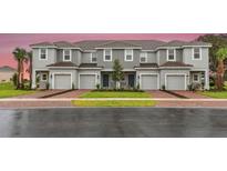 Three-unit townhome building with attached garages and landscaping at 195 River Front Way, Edgewater, FL 32141