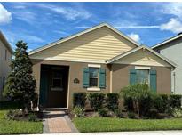Two-story home with beige and brown siding, teal shutters, and a landscaped front yard at 16613 Point Rock Dr, Winter Garden, FL 34787
