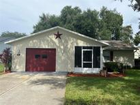 One story home with red door and screened porch at 821 Dundee Cir, Leesburg, FL 34788