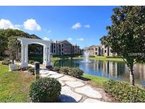 Community features a serene lake with walking paths and beautiful landscaping at 4400 Thornbriar Ln # A202, Orlando, FL 32822