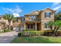 Two-story house with a two car garage, lush landscaping, and solar panels at 16328 Wind View Ln, Winter Garden, FL 34787