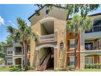 Building exterior with stairs and palm trees at 12500 Crest Springs Ln # 1013, Orlando, FL 32828