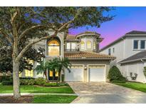 Grand two story house with a three-car garage and manicured landscaping at 364 Muirfield Loop, Reunion, FL 34747