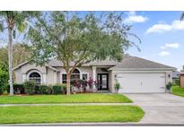 One-story home with a two-car garage and manicured lawn at 1409 Sutton Island Dr, Deland, FL 32724