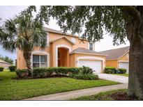 Two-story house with attached garage and manicured lawn at 2718 Lido Key Dr, Kissimmee, FL 34747