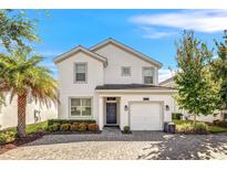 Two-story house with a white exterior and a two car garage at 4782 Kings Castle Cir, Kissimmee, FL 34746
