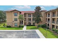 Multi-story building with stone accents and lush landscaping at 909 Charo Pkwy # 1021, Davenport, FL 33897
