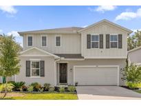 Two-story home with light beige exterior and dark gray shutters at 1069 River Otter Way, Deland, FL 32720