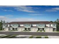 Front view of townhouses with attached garages and landscaping at 2986 Canary Ave, Davenport, FL 33837