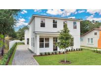 Modern two-story house with a white exterior, landscaped lawn, and paver driveway at 131 E Grant, Orlando, FL 32806