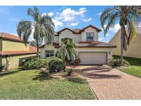 Two-story house with brick driveway and landscaped yard at 212 Crestrun Loop, Leesburg, FL 34748