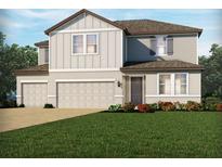 Two-story house with beige siding, two-car garage, and landscaping at 2122 Divot Dr, Daytona Beach, FL 32124