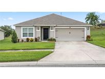 Single-story house with a two-car garage and well-maintained lawn at 205 Bella Verano Way, Davenport, FL 33897