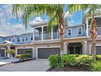 Two-story townhome with attached garage, balcony, and lush landscaping at 593 Lake Wildmere Cv, Longwood, FL 32750