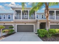 Two-story townhome with balcony, double garage and landscaping at 593 Lake Wildmere Cv, Longwood, FL 32750