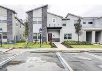 Modern two-story home with red door and landscaping at 690 Pebble Beach Dr, Davenport, FL 33896