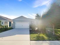 A grey house with a white garage door and a well-maintained lawn at 309 Gina Ln, Davenport, FL 33837