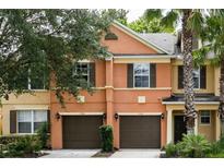 Two-story townhouse with attached garage and landscaping at 7582 Assembly Ln, Reunion, FL 34747