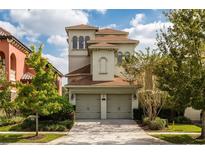 A stunning three-story home with a two-car garage, landscaped yard and stucco exterior at 1169 Castle Pines Ct, Reunion, FL 34747