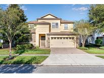 Two-story house with stone accents and a two-car garage at 1406 Moon Valley Dr, Davenport, FL 33896