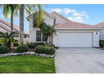 Two-story home with attached garage and manicured landscaping at 13336 Lake Turnberry Cir, Orlando, FL 32828