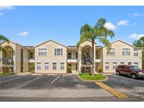 Condo building showcasing light beige walls, multiple units, and palm trees at 8850 Grand Palms Circle # B, Kissimmee, FL 34747