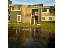 Two-story condo building with stairs leading to the entrance at 6110 Peregrine Ave # E05, Orlando, FL 32819
