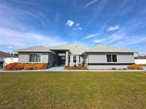 Gray house with a gray roof, landscaping, and a walkway at 15701 Sw 37Th Cir, Ocala, FL 34473