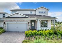 Two-story home with gray siding, stone accents, and a covered entryway at 10411 Park Estate Avenue, Orlando, FL 32836