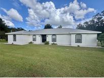 White house with black windows and a large green lawn at 475 Se 62Nd Ave, Ocala, FL 34472