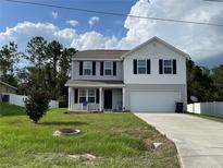 Two-story house with grey siding, a driveway, and a front yard at 29 Perch Dr, Kissimmee, FL 34759