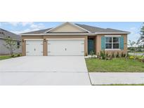 Two-story house with three car garage and teal accents at 2598 Sage Valley Way, Winter Haven, FL 33884