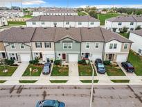 Aerial view of townhouses with attached garages and front yards at 947 Grandin St, Davenport, FL 33837