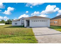 Single-story house with a two-car garage and well-maintained lawn at 893 Jarnac Dr, Kissimmee, FL 34759