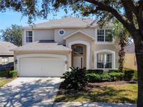 Two story house with beige exterior and a two-car garage at 2719 Lido Key Dr, Kissimmee, FL 34747