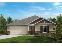 One-story house with a two-car garage and landscaped lawn at 212 Rivermill Way, Lake Wales, FL 33859