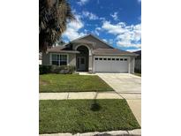 House exterior with two-car garage and landscaping at 2521 Oneida Loop, Kissimmee, FL 34747
