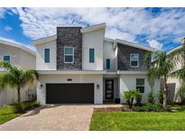 Modern two-story house with stone accents at 8896 Cabot Cliffs Dr, Davenport, FL 33896