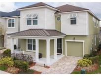 Two-story house with a green exterior, brown roof, and a porch at 1861 Sawyer Palm Pl, Kissimmee, FL 34747